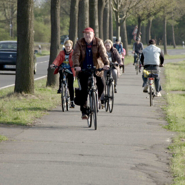 Radfahrer an eine vielbefahrenen Straße.
