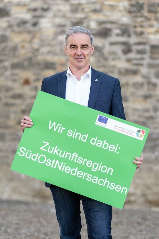 Ralf Sygusch hält das Bild "Wir sind dabei: Zukunftsregion SüdOstNiedersachsen"