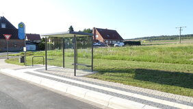 Das Symbolbild zeigt eine barrierefreie Bushaltestelle samt Wartehäuschen und Fahrradbügel.