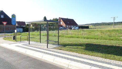 Das Symbolbild zeigt eine barrierefreie Bushaltestelle samt Wartehäuschen und Fahrradbügel.