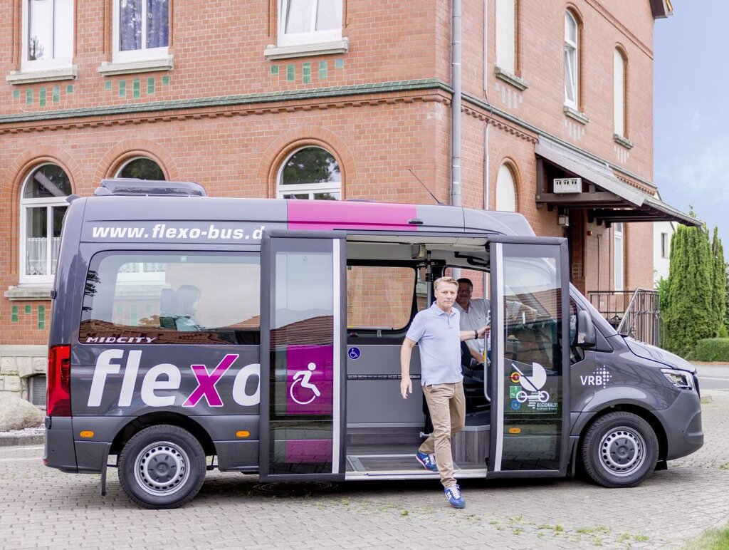 Ein Mann steigt aus einem flexo Bus aus.