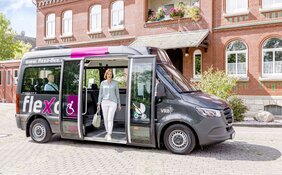 Eine Frau steigt aus einem flexo Bus aus