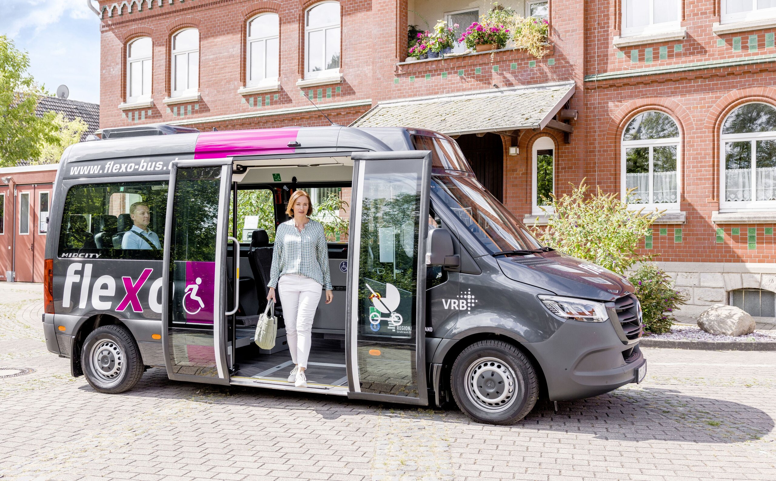 Eine Frau steigt aus einem flexo Bus aus