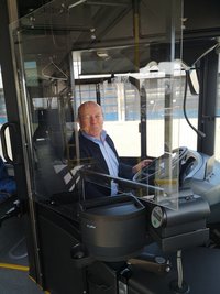 Busfahrer hinter Plexiglasscheibe