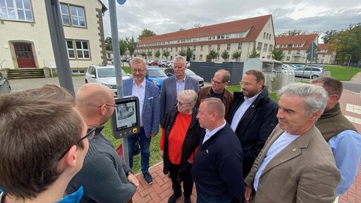 Politiker, Bürgermeister, KVG-Mitarbeiter und Regionalverbands-Mitarbeiter nehmen den ersten Digitalen Fahrplan an der Haltestelle Mariental, Horst im Landkreis Helmstedt offiziell in Betrieb. Foto: Regionalverband 